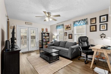 Office area featuring ceiling fan, wood finished floors, a textured ceiling, and french doors