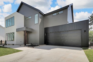 Contemporary home with concrete driveway and a ga