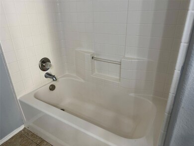 Bathroom featuring tiled shower / bath combo and tile patterned flooring