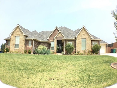 View of front of property featuring a front yard, a shingled roof, stone siding, and an attached garage