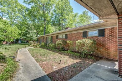 The wrap-around patio starts at the back of the carport (bottom right in the photo) and extends all the way around past the sunroom.