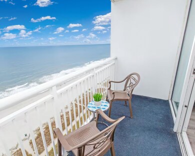 Balcony with view of water and beach
