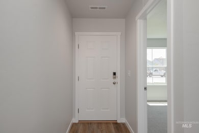 Doorway featuring baseboards and wood finished floors