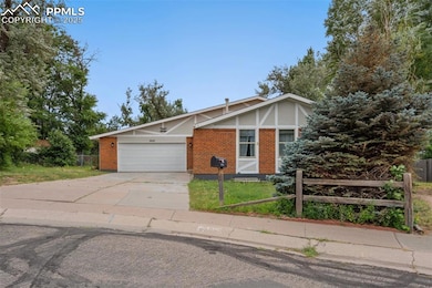 View of front facade featuring brick siding, driveway, and an attached garage