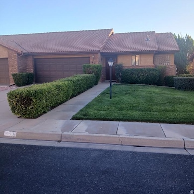 Single story home with a tiled roof, brick siding, a front lawn, and a garage