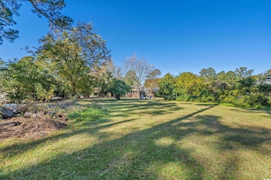 View of grassy yard featuring view of scattered trees
