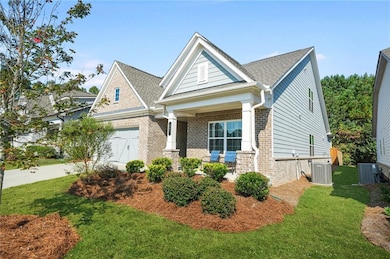 Craftsman inspired home with brick siding, roof with shingles, concrete driveway, and a front lawn
