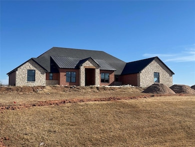 View of front of home featuring stone siding, a standing seam roof, a metal roof, and a front yard