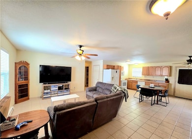 Living area with a ceiling fan, light tile pattern