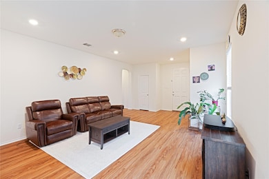 Living room featuring arched walkways, light wood