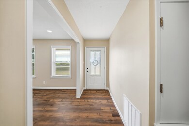 Entryway with dark wood-type flooring and baseboards