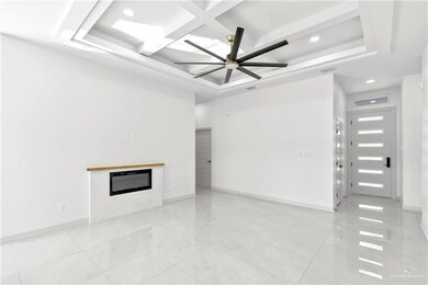 Unfurnished living room featuring ceiling fan and coffered ceiling