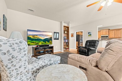 Living area featuring baseboards, ceiling fan, vi