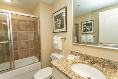 Full bath featuring vanity, toilet, and combined bath / shower with glass door