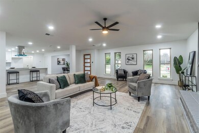 Living room with ceiling fan and light hardwood / 
