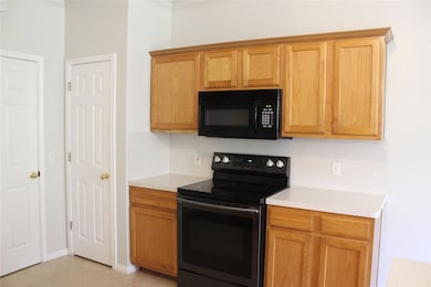 Kitchen with black appliances, light countertops,