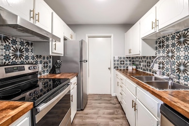 Kitchen featuring butcher block countertops, ligh