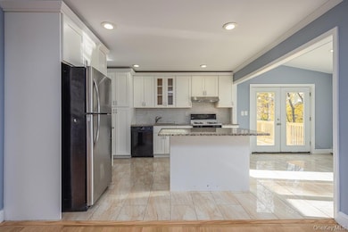 Kitchen featuring backsplash, freestanding refrigerator, glass insert cabinets, dark stone countertops, and french doors