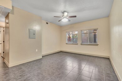 Spare room featuring tile patterned flooring, electric panel, and a ceiling fan