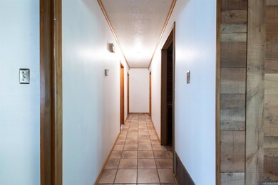 Corridor with a textured ceiling and light tile patterned floors