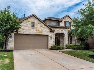 French country inspired facade featuring stone siding, concrete driveway, a front yard, and a garage