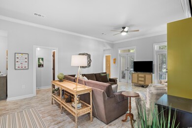 Living room featuring crown molding, ceiling fan, 