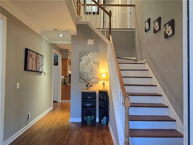 Staircase featuring wood finished floors and ornamental molding