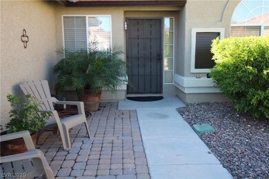 Charming front patio with pavers and shrubs.