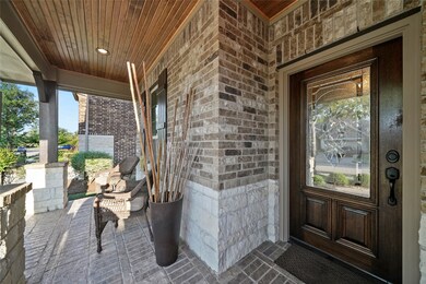 Enjoy this lovely front porch with brick pavers and tongue & groove ceiling!