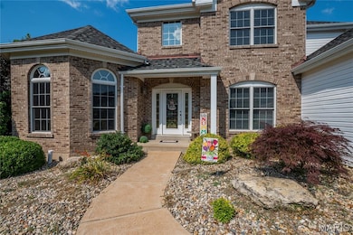 View of exterior entry featuring brick siding and a shingled roof