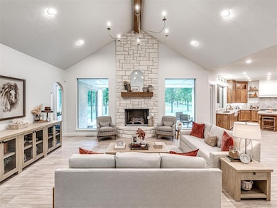 Living area featuring beam ceiling, healthy amount of natural light, light wood-type flooring, recessed lighting, and arched walkways
