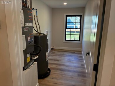 Utility room featuring water heater and heating unit
