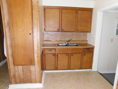 Kitchen featuring light countertops, brown cabinets, and tasteful backsplash