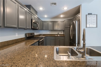 Kitchen with stainless steel appliances, a sink, r