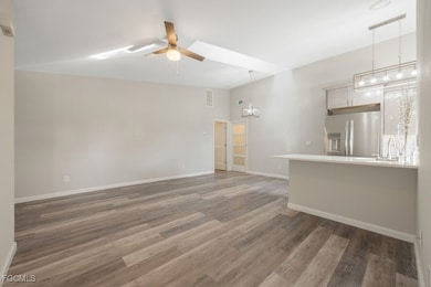 Unfurnished living room with ceiling fan and light