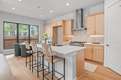 Kitchen with range, light brown cabinets, wall ch