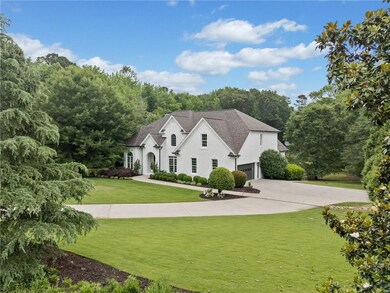 View of front of house featuring a garage, a front yard, driveway, and roof with shingles