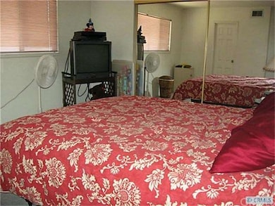 Large master bedroom with mirrored wardrobe doors.