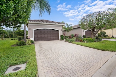 Mediterranean / spanish-style house featuring stucco siding, decorative driveway, a front lawn, a tile roof, and an attached garage