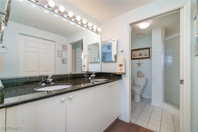 Bathroom featuring vanity, tile patterned flooring, toilet, and walk in shower