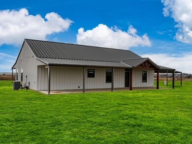 Back of property featuring central air condition unit and a lawn
