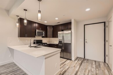 Kitchen with dark brown cabinetry, light countert