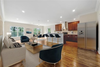Living room with wood-type flooring and crown molding