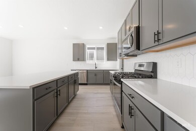 Kitchen featuring appliances with stainless steel finishes, tasteful backsplash, gray cabinets, recessed lighting, and a kitchen island