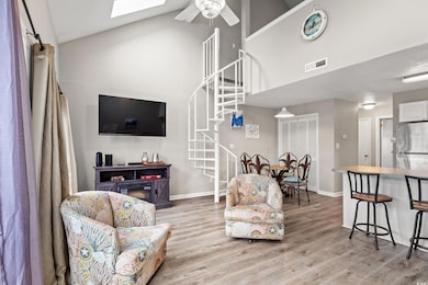 Living room with visible vents, ceiling fan, stairway, and light wood finished floors