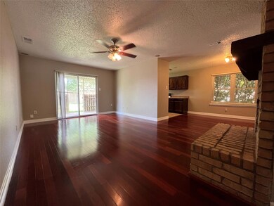 Unfurnished living room featuring ceiling fan, dar