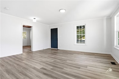 Unfurnished room featuring light wood-style flooring and ornamental molding