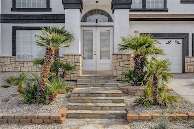 Property entrance featuring a garage, stucco sidin