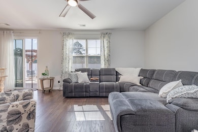 Living room featuring ceiling fan, visible vents, 