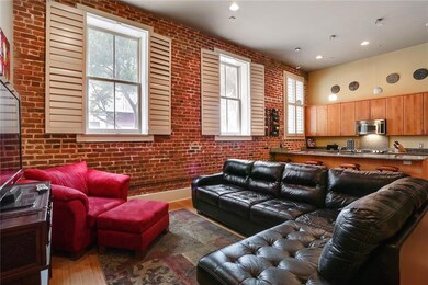 Beautiful brick wall and huge windows fill the liv